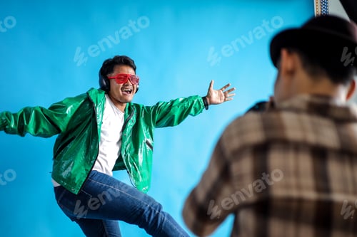 Preview: Photographer Capturing Man in Green Jacket Dancing Energetically with Headphones on