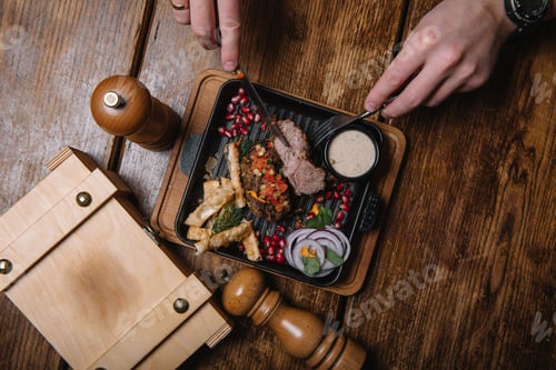 Preview: Man's hands holding a knife and a fork and preparing to it. A tasty steak.