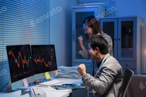 Preview: Two Asian businesspeople celebrating a successful investment while analyzing online stock market