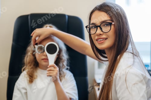 Preview: Helping, covering the eye. Little girl at the ophthalmologist clinic with doctor