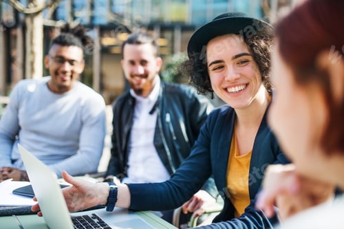 Preview: Group of young businesspeople using laptop outdoors in courtyard, start-up concept