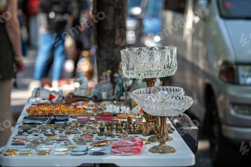 Preview: Open-Air Market Stall Displaying Vintage Jewelry And Antique Items During Sunny Day
