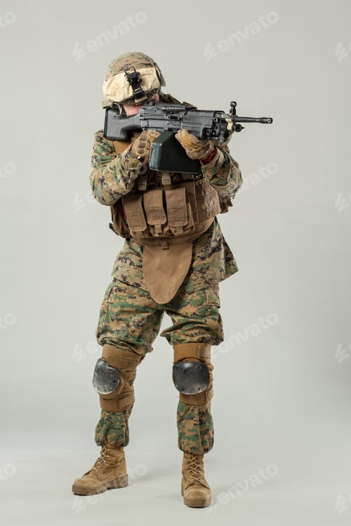 Preview: Soldier holds rifle in training area wearing camouflage uniform and protective gear