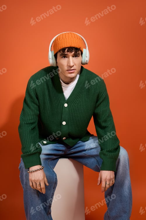 Preview: Stylishly dressed man showcases modern fashion with vibrant colors against a striking backdrop