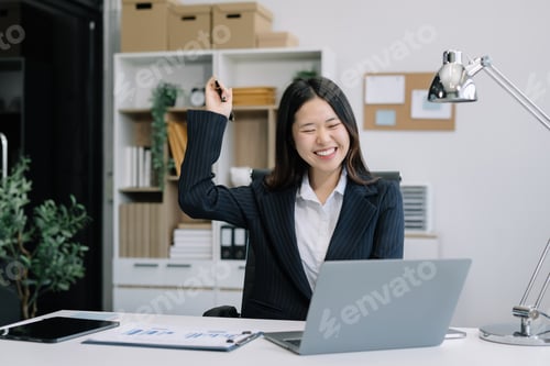 Preview: Excited Woman Celebrating Success at Office Desk