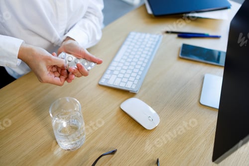 Preview: Business woman taking pill from blister pack