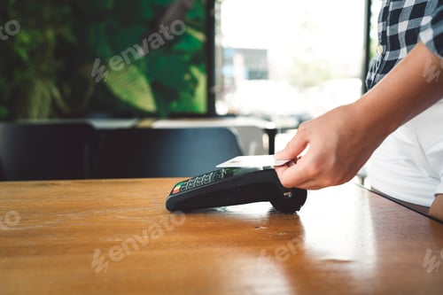 Preview: Person holding a card over the card reader sitting on the desk