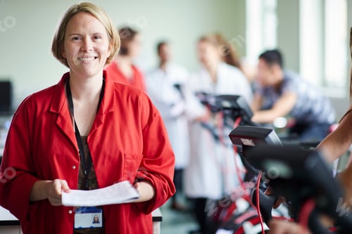 Preview: Smiling healthcare professional with documents in a busy hospital setting