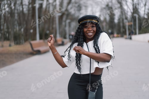 Preview: Photo portrait of cheerful black skinned girl. Afro girl walking in city park.