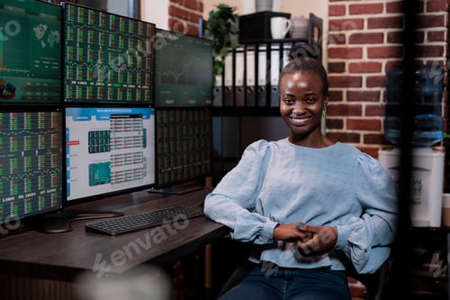 Preview: Financial investment company advisor sitting at multi monitor workstation while smiling heartily at