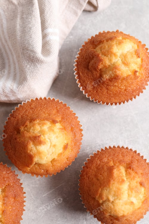 Preview: Tasty muffins on light grey table, flat lay. Fresh pastry