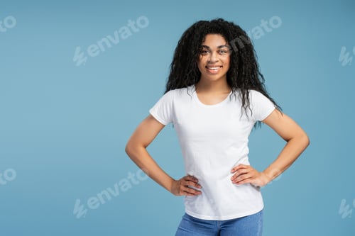 Preview: Young African American woman smiling and posing with hands on hips isolated on blue background