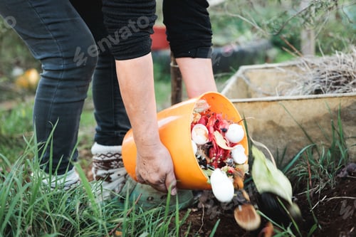 Preview: Person holding an orange bucket with compost and pouring into the soil in the rural garden