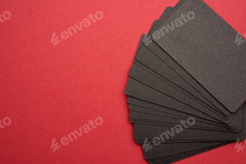 Preview: Stack of rectangular black paper blank business cards on red background