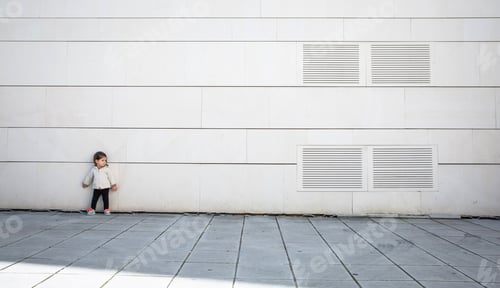 Preview: Little girl with sportive look posing over wall