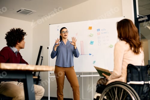 Preview: Young entrepreneur talking to coworkers about inclusive business strategy on presentation in office.