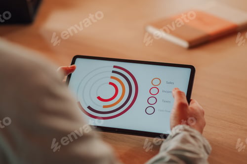 Preview: Businessman analyzing financial charts on digital tablet