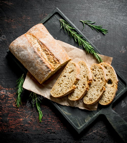 Preview: Sliced ciabatta bread on a cutting Board with rosemary.