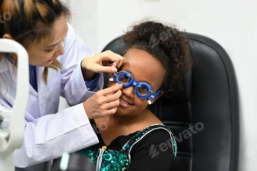 Preview: Smiling African woman checking eye vision with pediatric ophthalmologist.