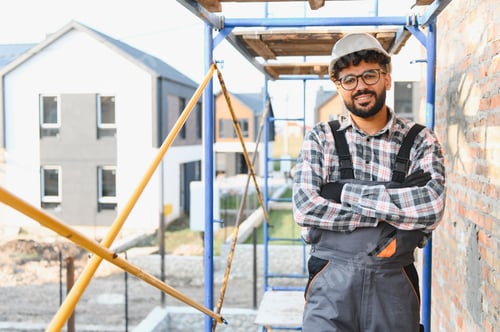 Preview: Builder posing at construction site wearing hard hat