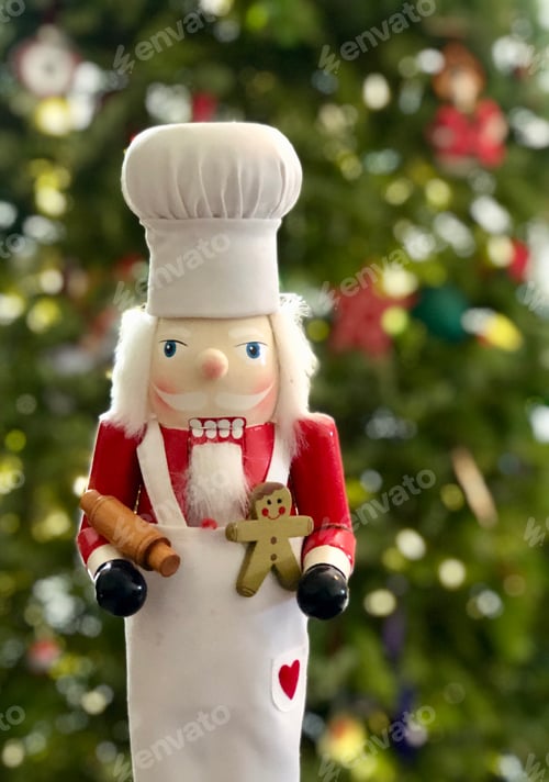 Preview: Chef baker nutcracker in front of Christmas tree bokeh Christmas lights