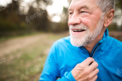 Preview: Senior runner in nature. Man resting, smiling. Close up.