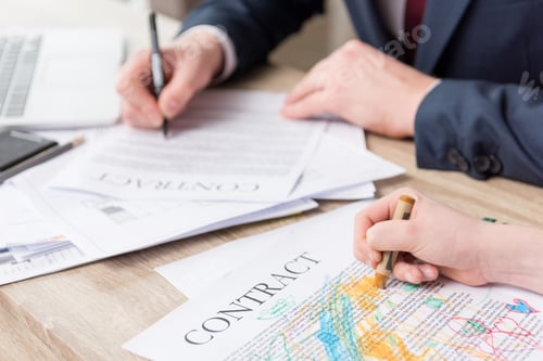 Preview: Businessman drawing on business papers with son at office