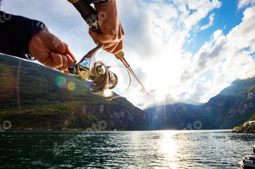 Preview: Woman fishing on Fishing rod spinning in Norway.