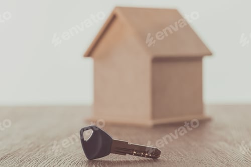 Preview: key and small house on wooden table, saving concept