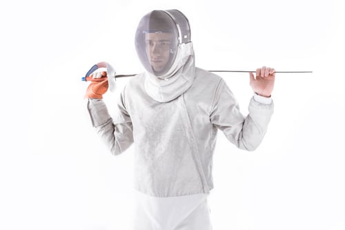Preview: portrait of serious fencer in uniform holding rapier isolated on white