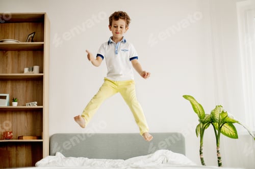 Preview: A little boy jumps on his bed in the bedroom and laughs.