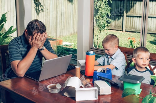 Preview: Father trying to work on the Internet on a laptop while kids making crafts from recycled materials.