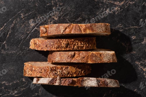 Preview: Top View of Fresh Bread Slices on Stone Black Surface