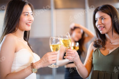 Preview: Asian woman toasting wine glass together