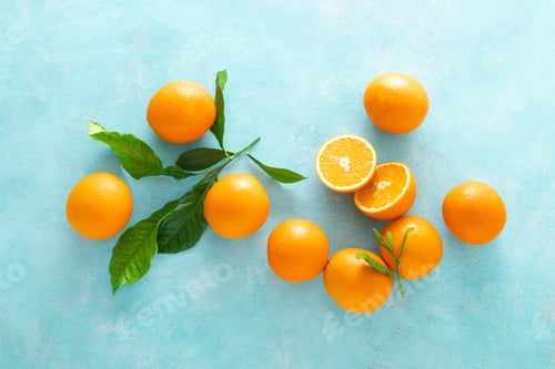 Preview: Orange freshly squeezed juice in glass and fresh fruits on a blue vivid background, top view