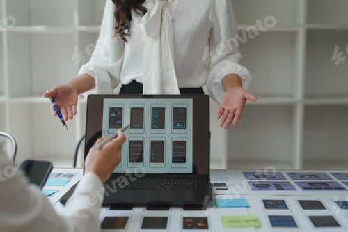 Preview: Ux ui designers discussing mobile app interface design on laptop