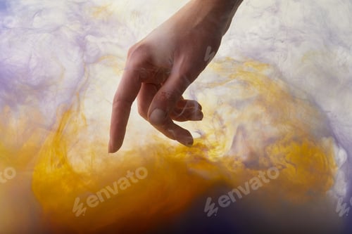 Preview: partial view of hand in water with orange and purple paint