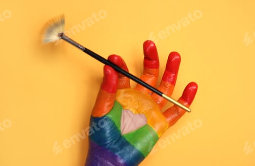 Preview: Colorful painted hand holding a paintbrush