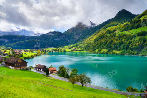 Preview: Lungern, canton of Obwalden, Switzerland. A view of rural homes in a green meadow.