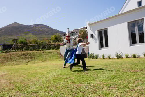 Preview: Mother and son in superhero costume playing in the backyard