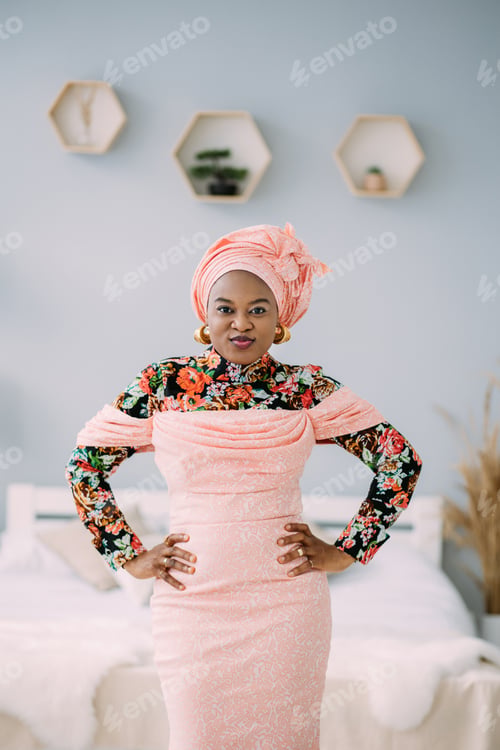 Preview: Attractive African-american fashion woman in pink colorful traditional dress and headscarf in modern