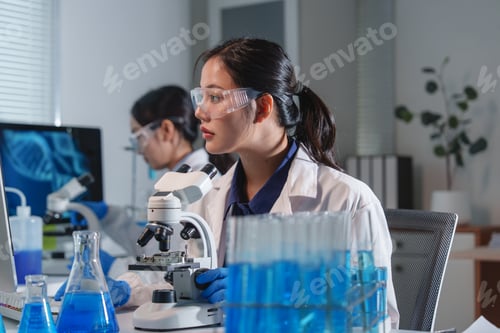 Preview: Scientists working with microscope and computer in laboratory