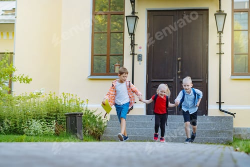 Preview: Happy caucasian children running from school with backpacks on sunny day. Begining of academic year