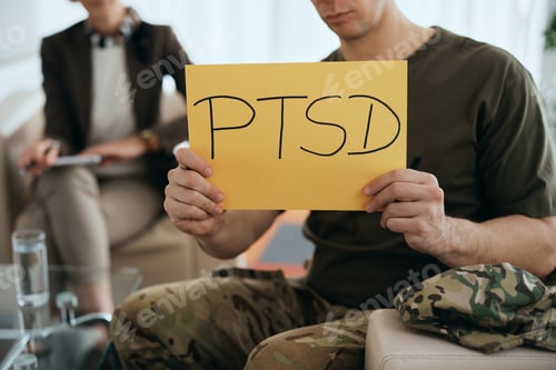 Preview: Close-up of veteran holding PTSD placard at mental health counseling center.