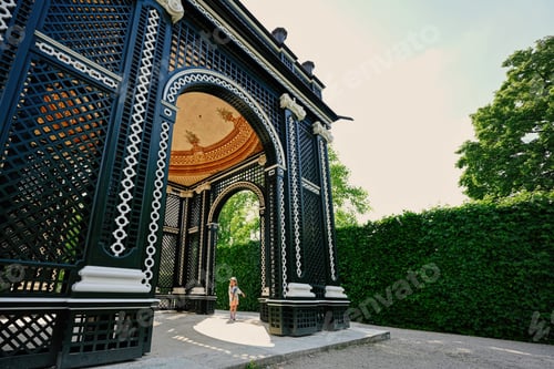 Preview: Baby girl under wooden arbor arch at Schonbrunn Palace in Vienna, Austria.