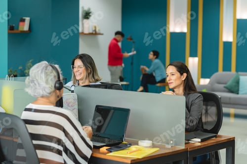 Preview: Group of multiethnic colleagues working in office in daytime