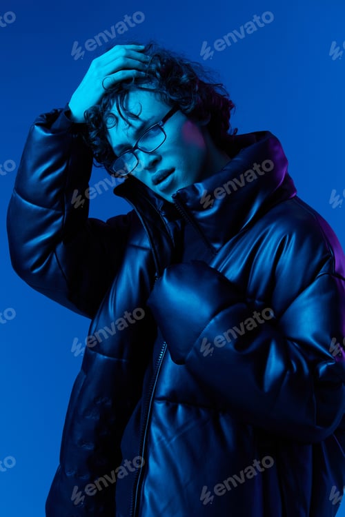 Preview: Man in winter down jacket model poses with a smile with glasses, hipster lifestyle, portrait blue