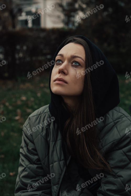 Preview: Crying young woman in hood with mascara smudges