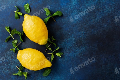 Preview: Two fresh lemons in dark blue plate on turquoise concrete background. Food background. Top view