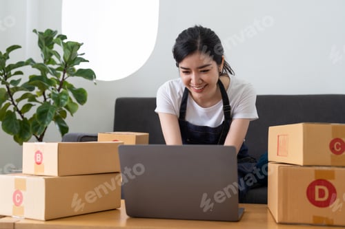 Preview: Young business woman working online e-commerce shopping at her shop. Young woman seller prepare